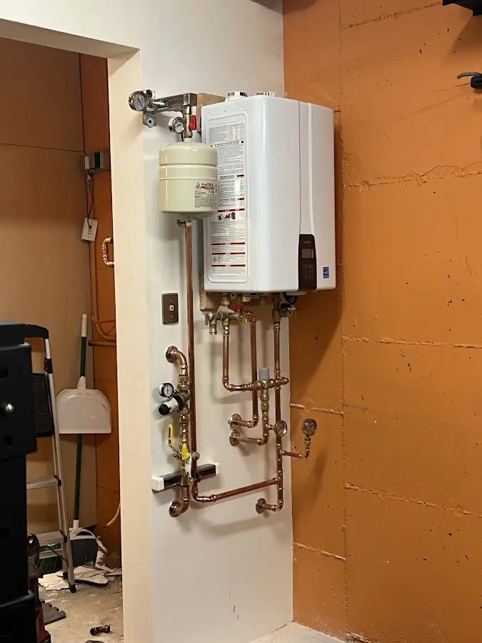 Plumbing technician inspecting water heater connections in Voorhees